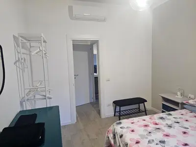 a bedroom with a bed and a chair and a ladder at EMHouse in Rome
