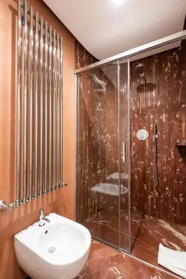 a bathroom with a glass shower and a sink at My Trevi Suite & Apartment in Rome