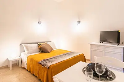 a small bedroom with a bed and a flat screen tv at Porta Pia - cozy flat in Rome