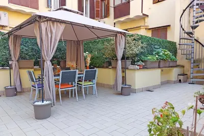 a table and chairs under an umbrella on a patio at dolce casa colosseo 1 - 2 in Rome