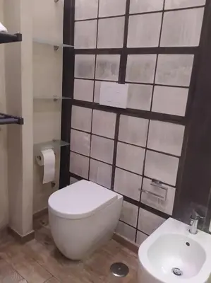 a bathroom with a white toilet and a sink at Irori Boutique House in Rome