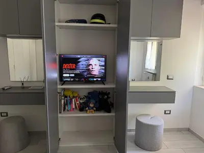 a living room with a tv on a shelf at camera con bagno privato in Rome
