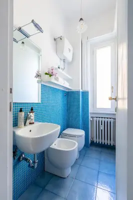 a blue tiled bathroom with a sink and a toilet at Casa Fontanella by Hili in Rome