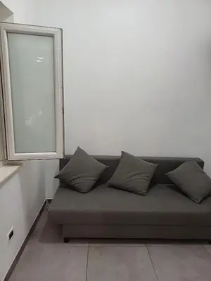 a couch with pillows in a room with a window at gt TRASTEVERE STATION HOUSE in Rome