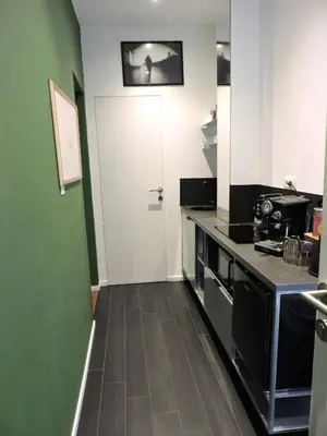 a kitchen with a white door and a green wall at Art Lab Residence in Rome