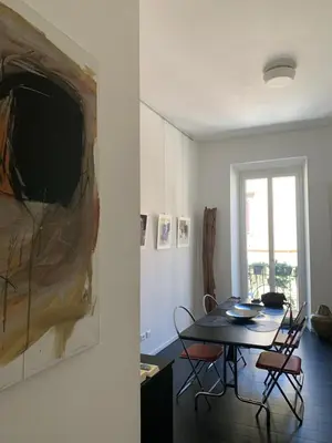 a dining room with a table and chairs and a painting at Art Lab Residence in Rome