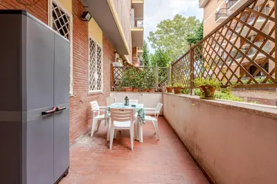 a patio with a table and chairs on a balcony at Modern apartment in Portuense in Rome