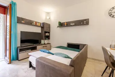 a living room with two beds and a tv at Modern apartment in Portuense in Rome