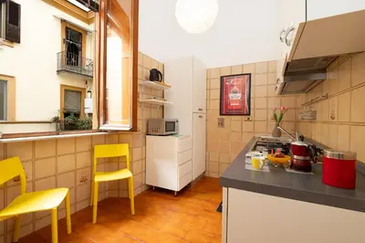 a kitchen with yellow chairs and a counter top at Casa Lucrezio Saint Peter's in Rome