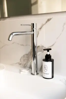 a bathroom sink with a bottle of soap next to a faucet at Barigelli Apartment in Rome