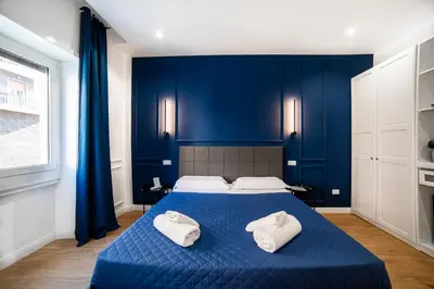 a blue bedroom with a bed with two white pillows at Barigelli Apartment in Rome