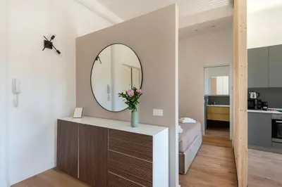 a room with a mirror on a dresser and a bedroom at White Flat 60 -San Lorenzo- in Rome