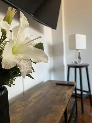 a vase with a white flower on a wooden table at Casa Giulia Monteverde in Rome