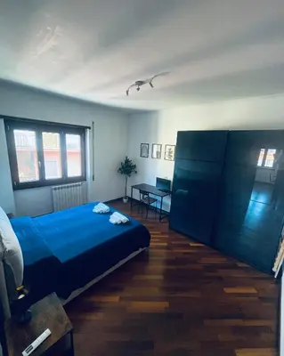 a bedroom with a blue bed and a table at Casa Giulia Monteverde in Rome