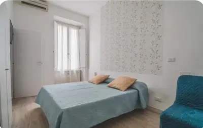 a bedroom with a bed and a blue chair at Green House in Rome