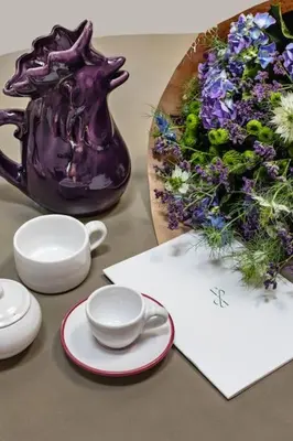 a table with a purple pitcher and a bouquet of flowers at Casa Garibaldi, a Burghesius home in Rome