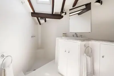 a white bathroom with a sink and a mirror at Casa Garibaldi, a Burghesius home in Rome