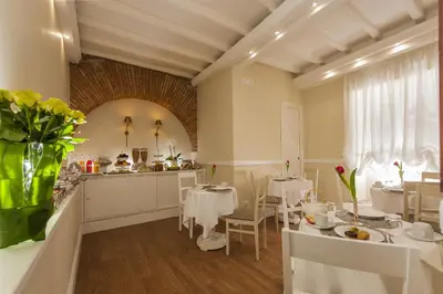 a dining room with white tables and white chairs at La Residenza del Sole al Pantheon in Rome