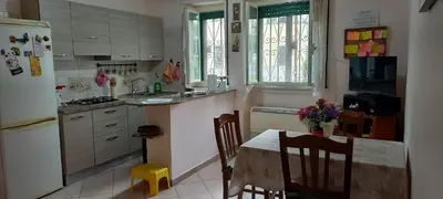 a kitchen with a table and chairs and a refrigerator at ary's house in Rome
