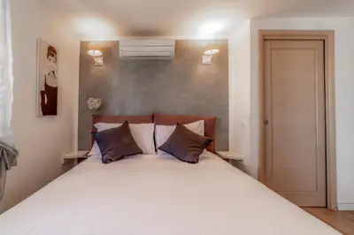 a bedroom with a large white bed with two pillows at Cozy Penthouse with Terrace and Rome View in Rome