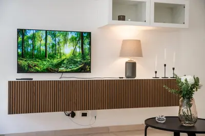 a living room with a tv on a wall at Bernadette Apartment - Vaticano area in Rome