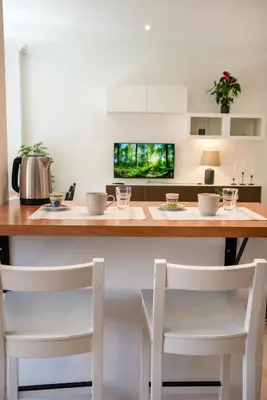 a kitchen with a wooden counter with two chairs at Bernadette Apartment - Vaticano area in Rome