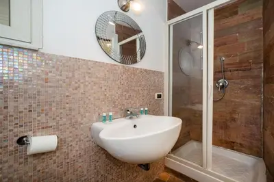 a bathroom with a white sink and a shower at Bernadette Apartment - Vaticano area in Rome
