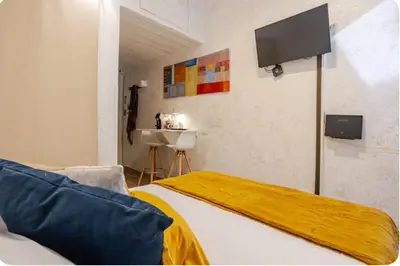 a bedroom with a bed with a television on the wall at Minisuite a Borgo Pio 