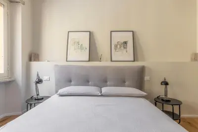 a bedroom with a large white bed with two tables at La Dolce Vita - Trastevere Station in Rome