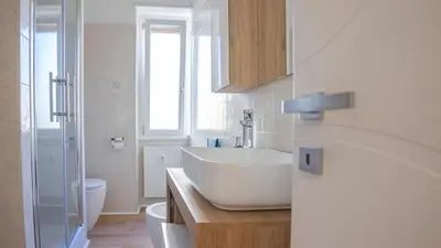 a white bathroom with a sink and a toilet at Casa Bonnet - Elegant Stay near Trastevere & Gianicolo in Rome