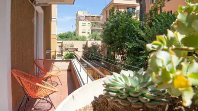 a table and chairs on a balcony with a cactus at Casa Bonnet - Elegant Stay near Trastevere & Gianicolo in Rome