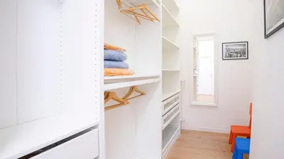 a walk in closet with white walls and wood floors at Casa Bonnet - Elegant Stay near Trastevere & Gianicolo in Rome