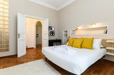 a bedroom with a large white bed with yellow pillows at Comfortable & Cozy by NDP rent in Rome
