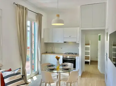 a kitchen with a table and chairs and a kitchen with white cabinets at Roma San Pietro rooftop view in Rome