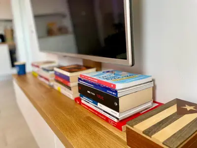 a pile of books sitting on a table under a mirror at GreenChill House - West Rome in Rome