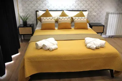 a bedroom with a yellow bed with towels on it at Sistine Chapel View Rooms Check-in From 3 Pm To 10 Pm in Rome