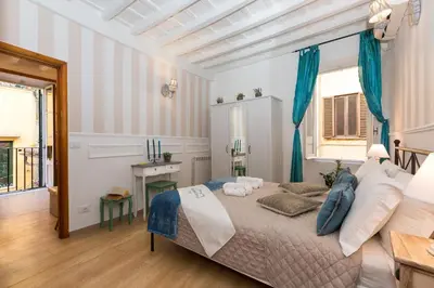 a bedroom with a large bed with blue curtains at Boutique Domus Navona Librari in Rome