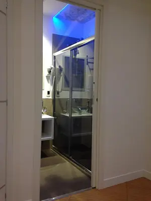 a bathroom with a glass shower with a sink at Valle Aurelia House in Rome