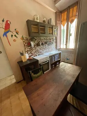 a kitchen with a wooden table and a refrigerator at Vatican Mamma Roma in Rome