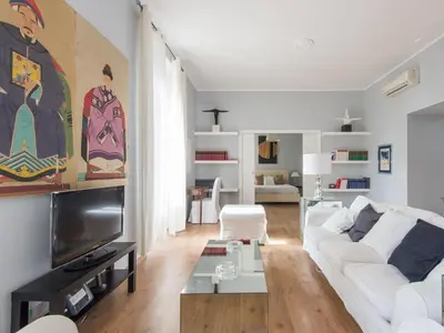 a living room with a white couch and a tv at Apartment La Casa dell'Arte by Interhome in Rome