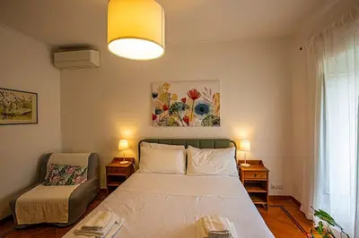 a bedroom with a bed and a chair in it at Dimora al Colosseo, 2 bedrooms in Rome