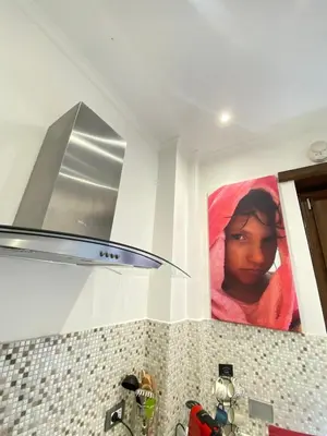 a kitchen with a painting of a girl on the wall at Casa Tua a Roma Centro con box auto tra Stadio Olimpico e Vaticano in Rome