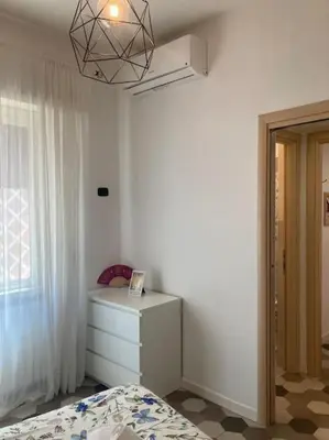 a bedroom with a bed and a dresser and a window at Garbatella Garden Home in Rome