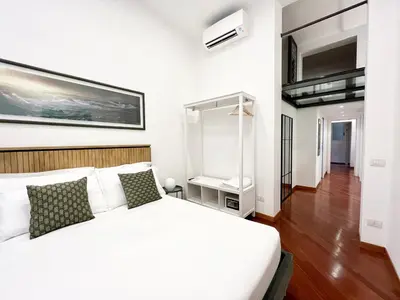 a bedroom with a white bed and a mirror at Trastevere Wondersuite in Rome
