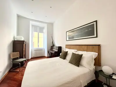 a bedroom with a white bed with a picture on the wall at Trastevere Wondersuite in Rome