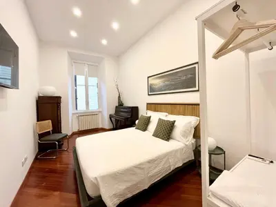 a bedroom with a white bed and a window at Trastevere Wondersuite in Rome