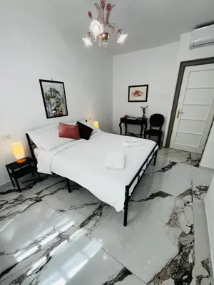 a bedroom with a large white bed with marble floors at Escape to the Eternal City Vatican Stay in Rome