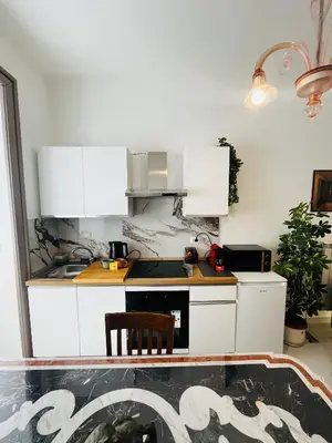 a kitchen with white cabinets and a stove at Escape to the Eternal City Vatican Stay in Rome