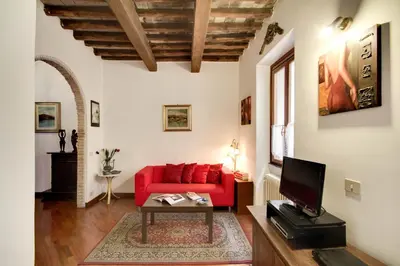 a living room with a red couch and a table at Stunning Pantheon Apartment in Rome