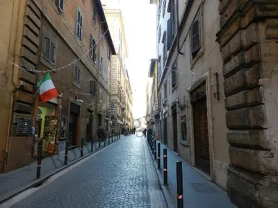 an empty street in a city with buildings and a flag at Stunning Pantheon Apartment in Rome